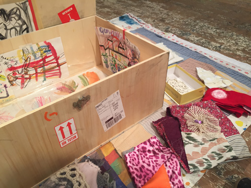 Susan Cianciolo. REMEMBER Kids Activity Kit, 2004-14 (detail). Wooden box, Petite Grand book image, Run Home digital prints by Wallace Lester, ink on paper, on quilt with Run Home textile, sweater, 3 dresses, tights, wings, box of clay pieces, star pin, crystals, 19.5 x 76 x 53 in (49.53 x 193.04 x 134.62 cm). Unique. Photograph: Harry Hughes.