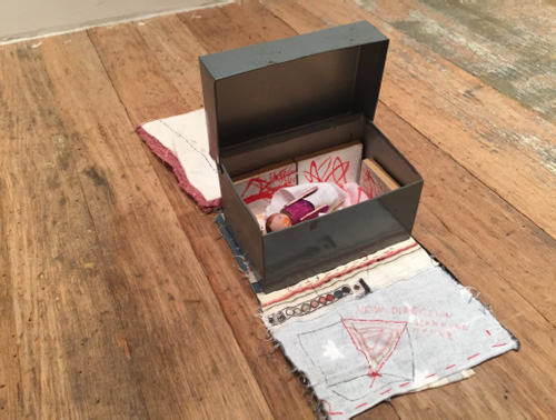 Susan Cianciolo. Mini Me, 2008-15. Steel box, coloured wood, paintings on panel, torn paper, penny, fabric, on vintage 1970s embroidery with textile by Mike Mills, 7 x 7 x 18 in (17.78 x 17.78 x 45.72 cm). Unique. Photograph: Harry Hughes.